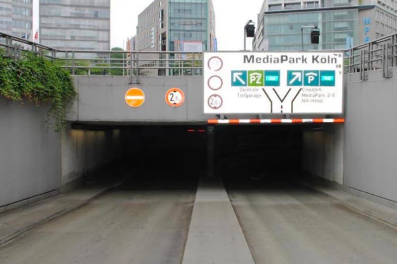 Einfahrt zur Tiefgarage MediaPark Köln mit Rampenabfahrt, Höhenbegrenzung 2,0 m und Durchfahrtsverbotsschild.