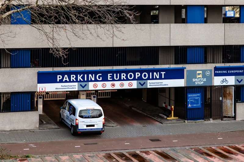 Einfahrt einer mehrstöckigen Parkhalle mit Schild Parking Europoint und Lieferwagen am Eingang.