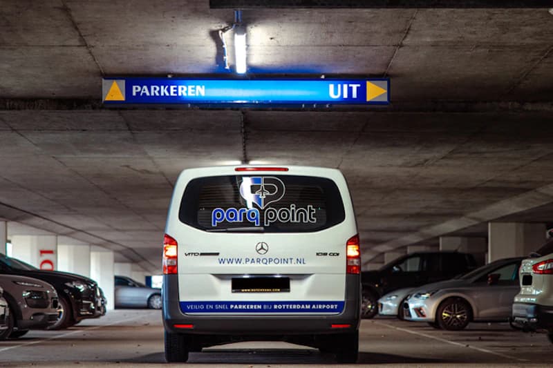Rückansicht eines weißen Parq Point Transporters in einer Parkhalle unter dem Schild PARKEREN UIT.